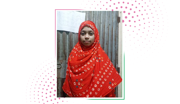 Ayesha stands in front of her home.