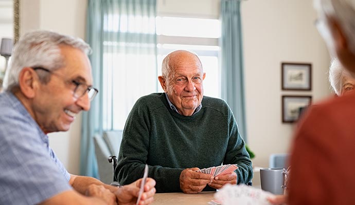 A group of smiling senior citizens sitting around a table