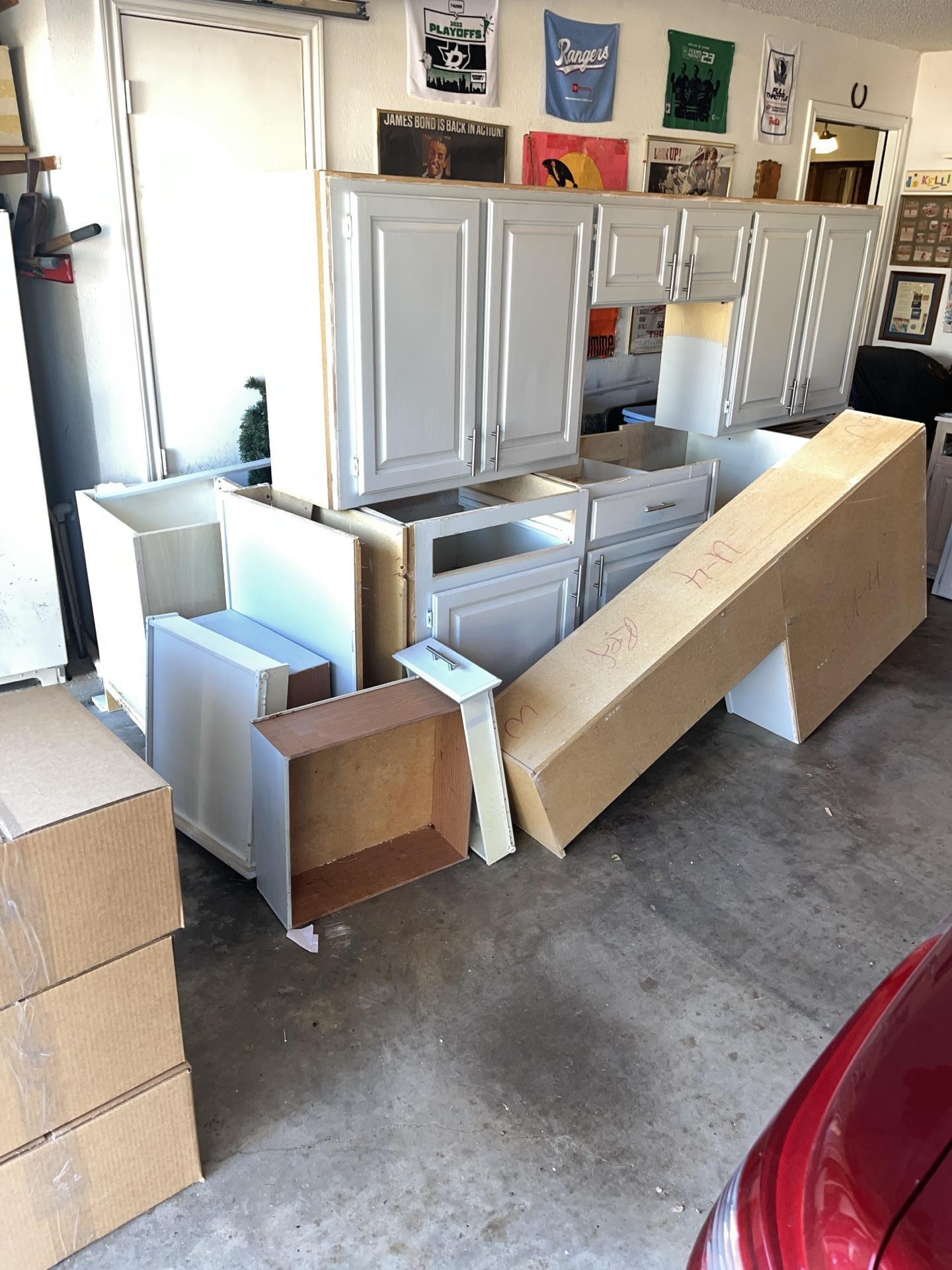 Organization of salvaged kitchen cabinetry and components during a professional pack-out service, ensuring items are protected while the property undergoes deep cleaning and moisture removal.