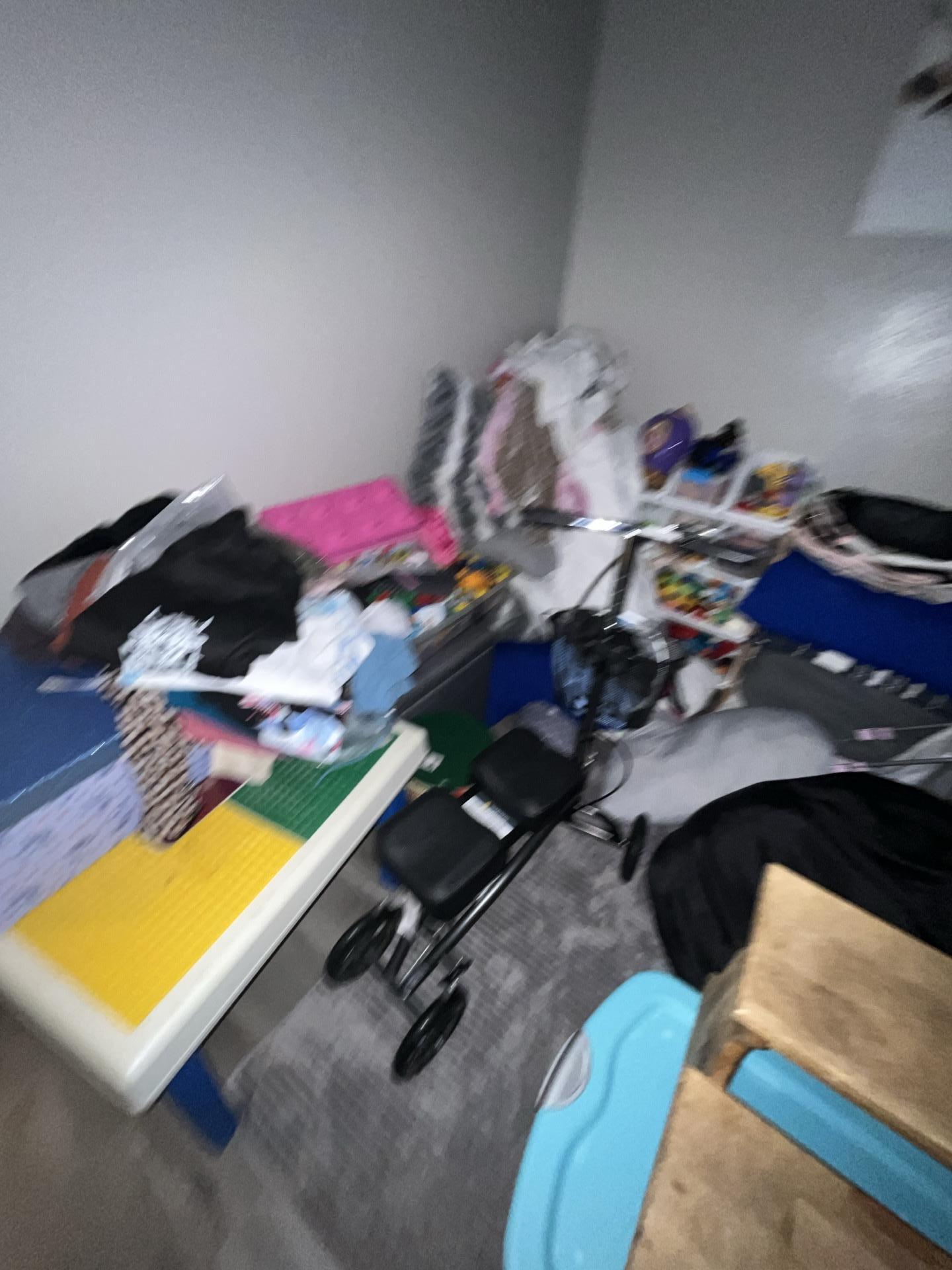 Bedroom contents moved during water damage restoration, indicating affected areas in the room, likely a secondary bedroom.