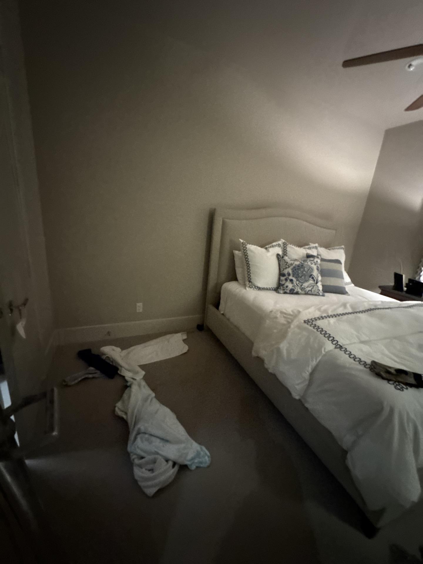 Bedroom with bed and clothes on the floor, showing an interior space impacted by water damage needing restoration.