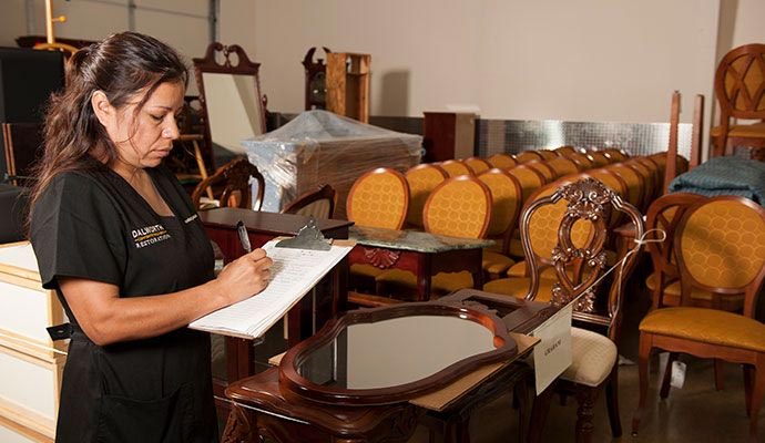 Person taking inventory of stored furniture in a storage area