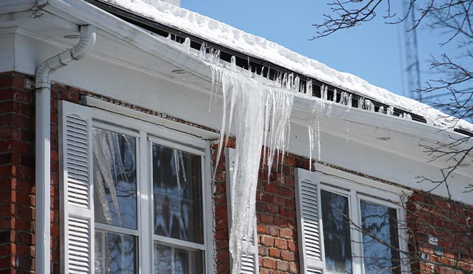 Damaged roof covered with ice after heavy snowfall