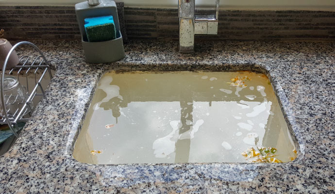 Kitchen sink filled with water due to clogged plumbing
