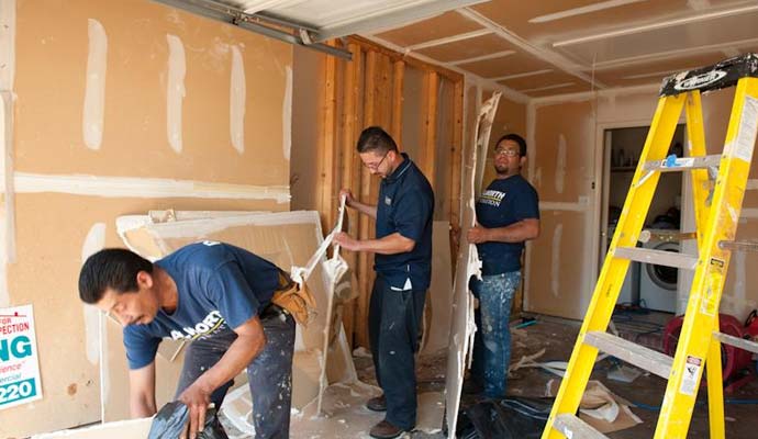 Restoration workers removing drywall demolition Restoration workers removing drywall demolition