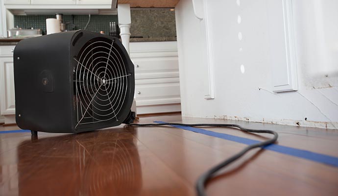 Water damage drying equipment on hardwood floor during restoration